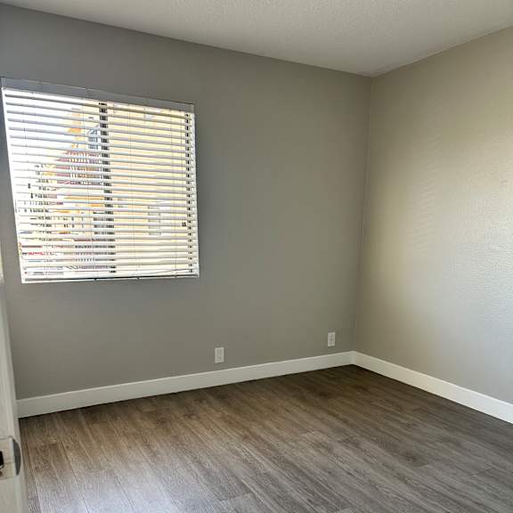A room with a window covered by blinds.