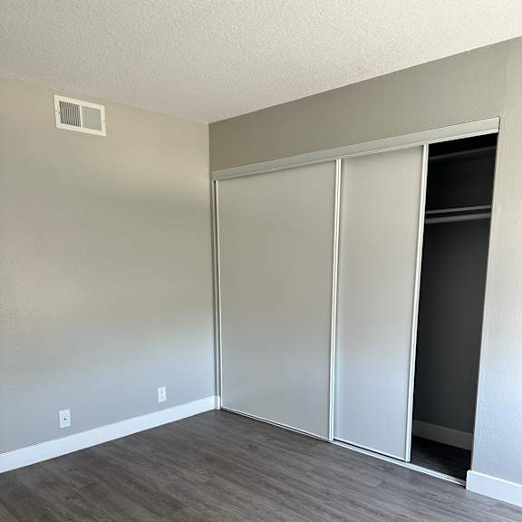 A white ceiling fan in a room with a grey wall.