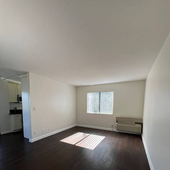 A white bench is in a room with a window.