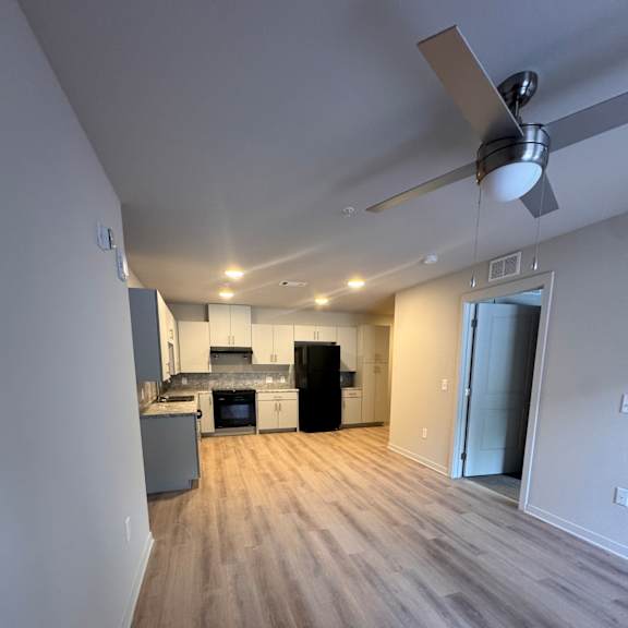 A modern kitchen with a ceiling fan and a skylight.
