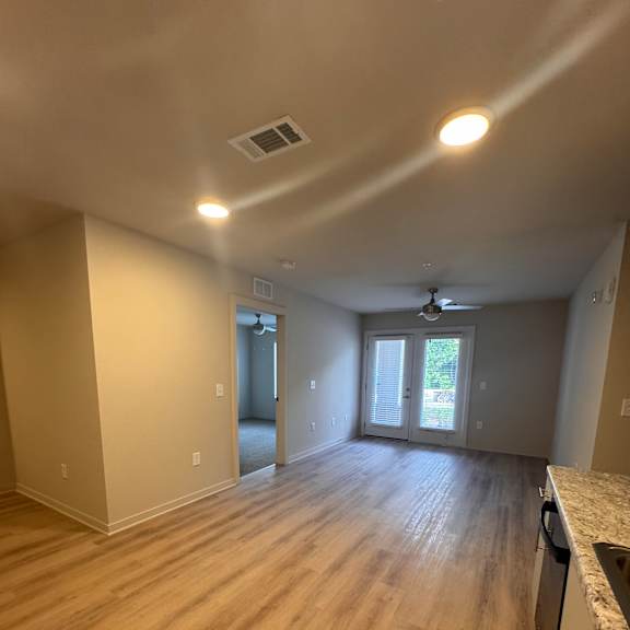 A room with wooden flooring and a window.