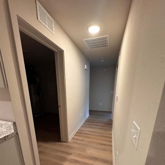 A room with a desk and a window with blinds.