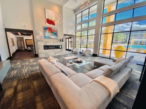 Living Room with Couch and Large Window at Fusion Apartments in Jacksonville, FL 32256