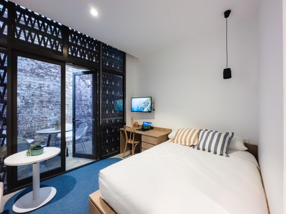 a bedroom with a bed and a table and a tv