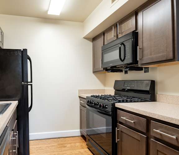 Apartment kitchen with appliances, cabinets, and countertops-Clarendon Court Apartments, Arlington, VA