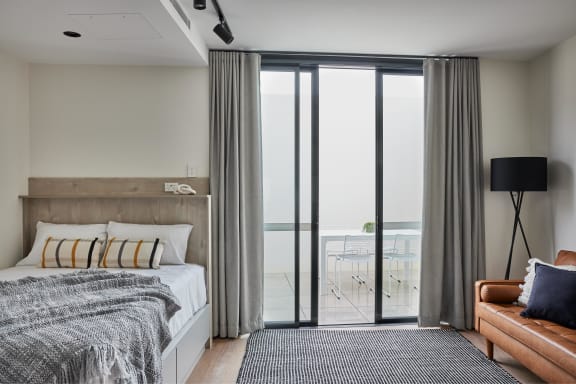 a bedroom with a bed and sliding glass doors