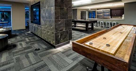 a game room with a shuffleboard table and a pool table