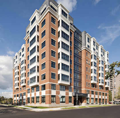 A modern multi-story building with a mix of brick and glass facade.