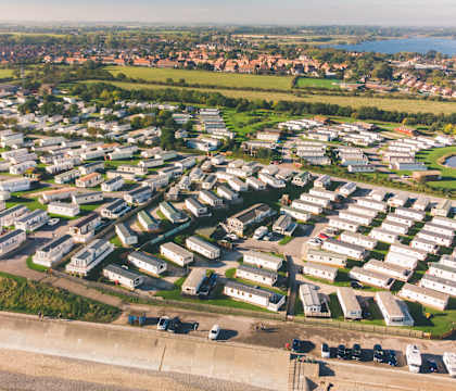 A bird's eye view of a residential area with houses and a beach.