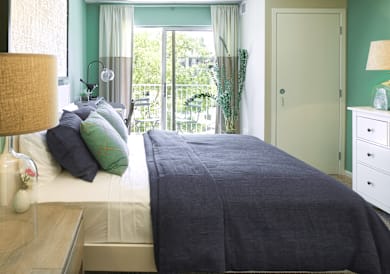 A bedroom with a bed, nightstand, and lamp.