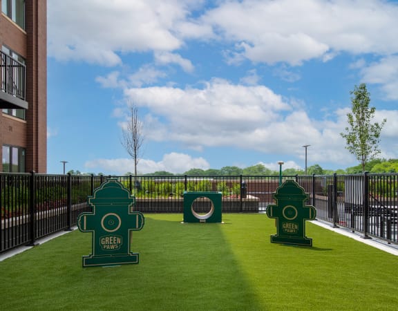 a grassy area with two green fire hydrants in front of a building