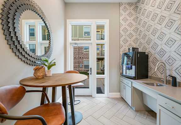 a kitchen with a table and chairs and a door to a balcony