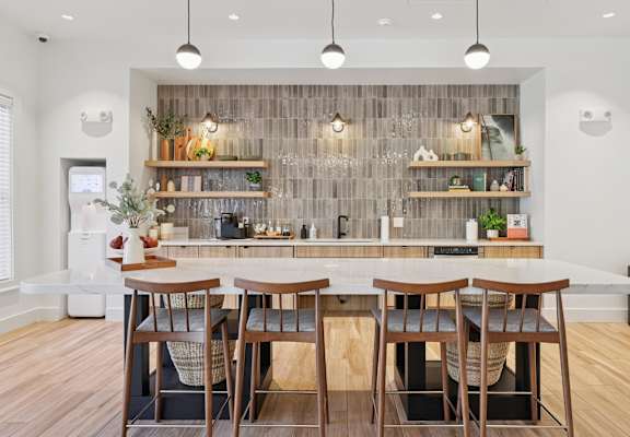 A modern kitchen with a wooden table and chairs.