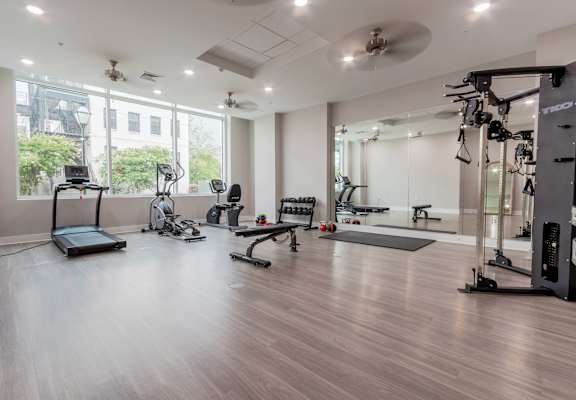A spacious gym with a variety of equipment including treadmills, weights, and exercise machines.