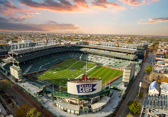 An aerial view of a football stadium with the words "Chicago Cubs" on the scoreboard.