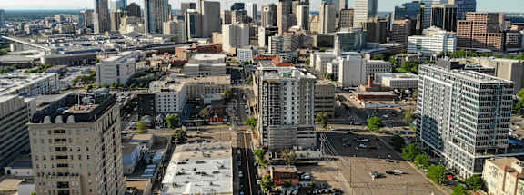 A cityscape with a mix of modern and older buildings under a clear sky.