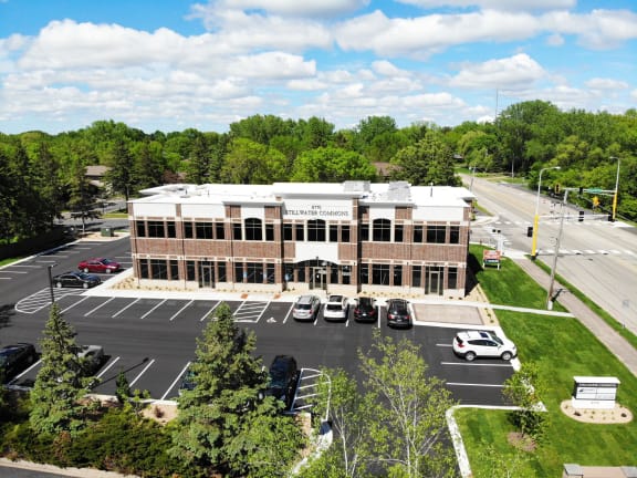 an aerial view of a building with cars in a parking lot