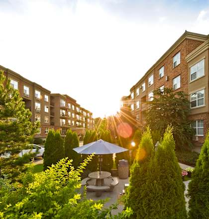 A sunny day at a residential complex with a garden in the foreground.