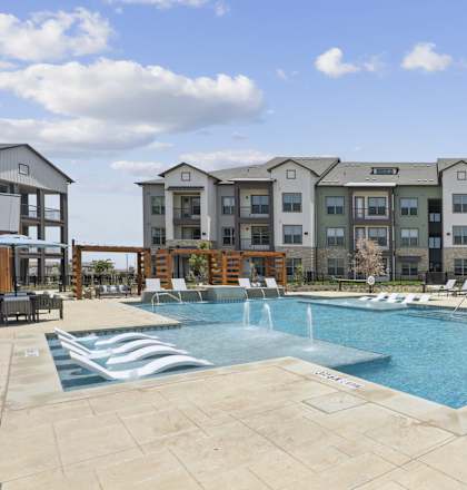 A large swimming pool with a fountain in the middle of it.