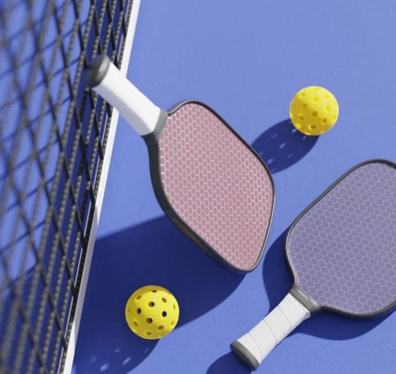 three tennis rackets and two yellow balls on a court