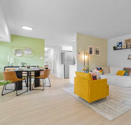 a living room and dining room with a yellow couch and yellow chairs