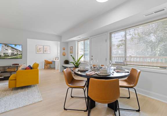 a dining room with a table and chairs and a tv on the wall