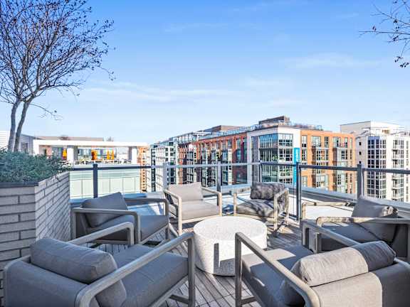 A patio with grey couches and a tree at Coda on Half Apartments, Washington