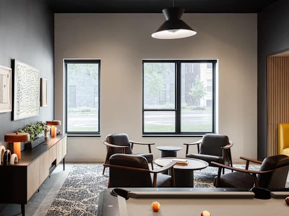 A room with a pool table and a view of the street outside.
