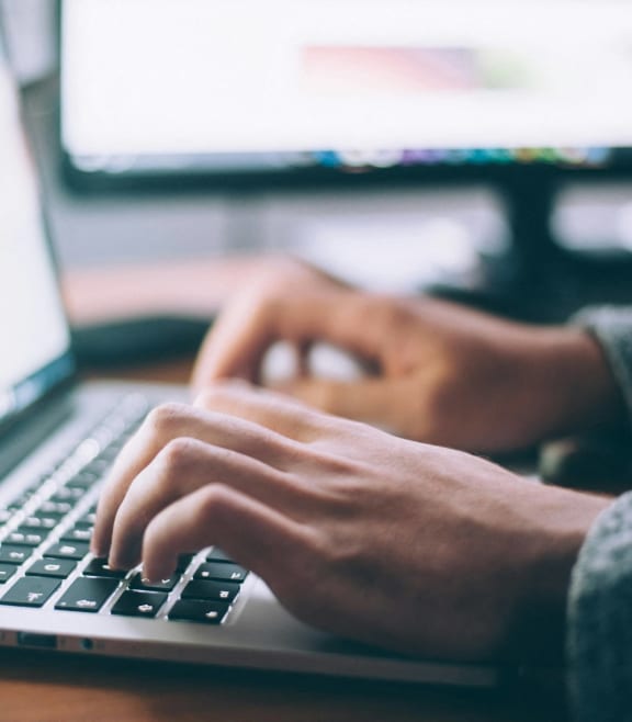 a person typing on a laptop computer
