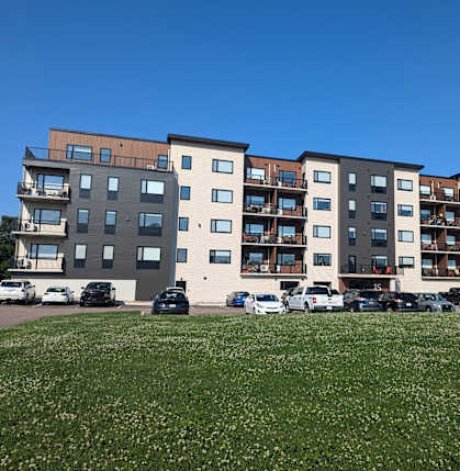 a new apartment building with cars parked in front of it