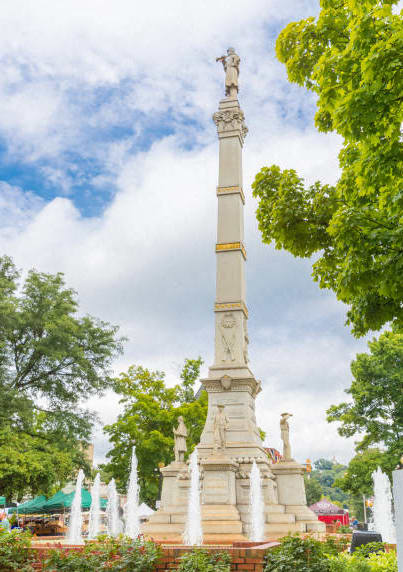 a tall tower with a statue on top of a fountain