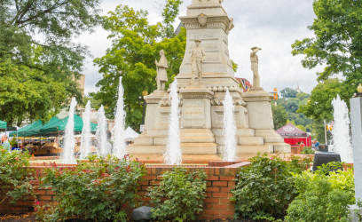 a tall tower with a statue on top of a fountain