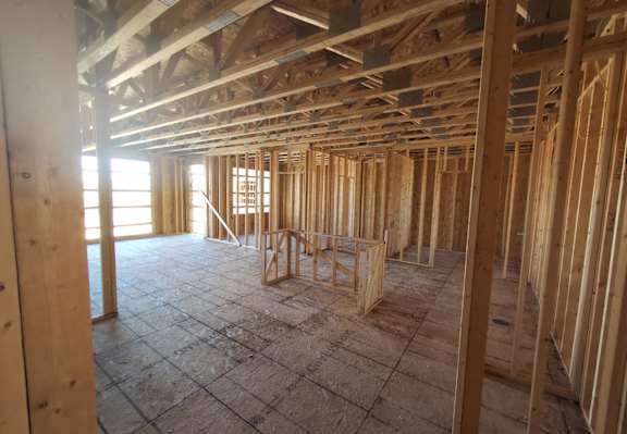 a house under construction with wood studs and wooden floors