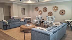 A living room with a grey sofa, two chairs and a coffee table.