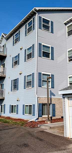 A large apartment building with a white garage door in front.