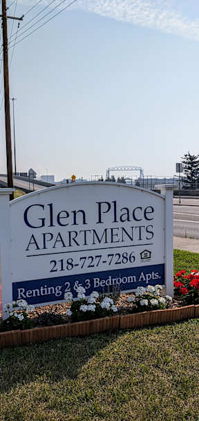 Glen Place Apartments sign with flowers in the foreground.