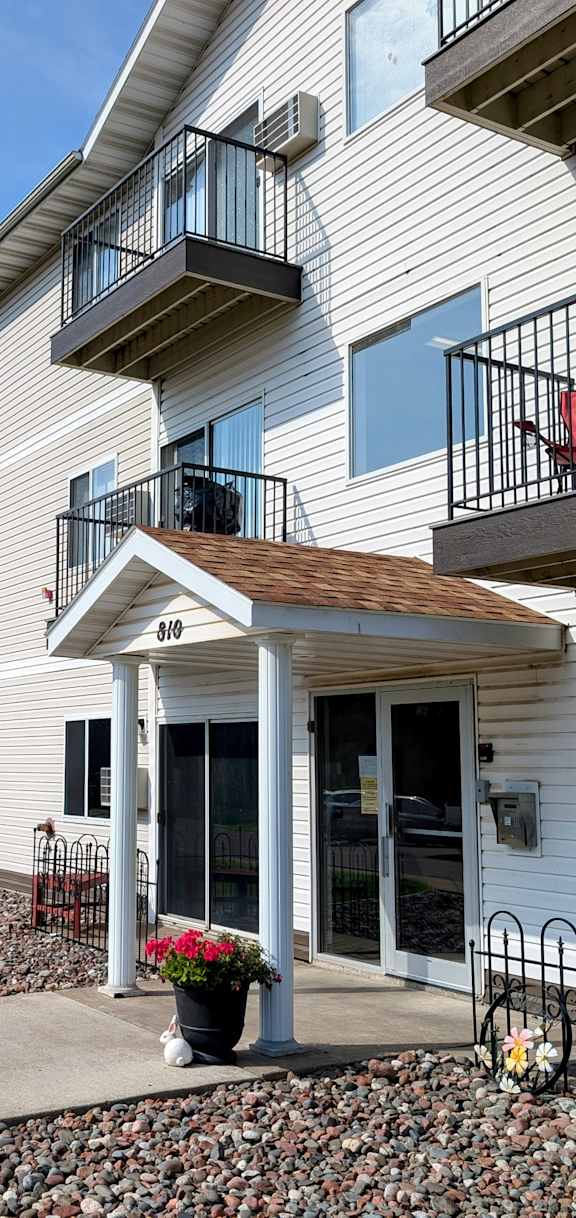 Apartment building with a red chair on the balcony.