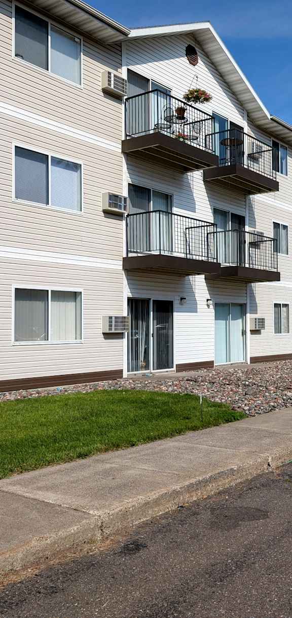A multi-story apartment building with a balcony on the second floor.