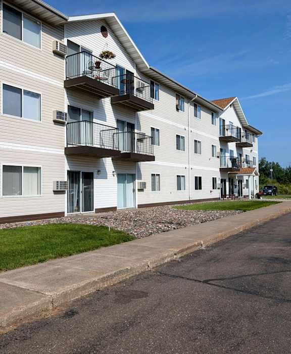 A multi-story apartment building with a balcony on the second floor.