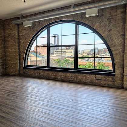 an empty room with a large window and wooden floors