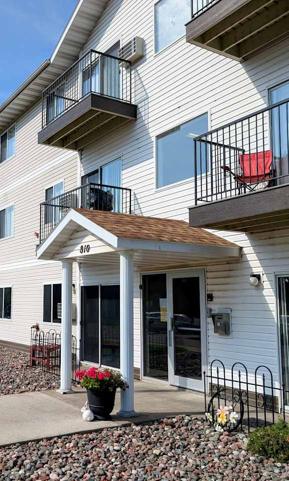 Apartment building with a red chair on the balcony.