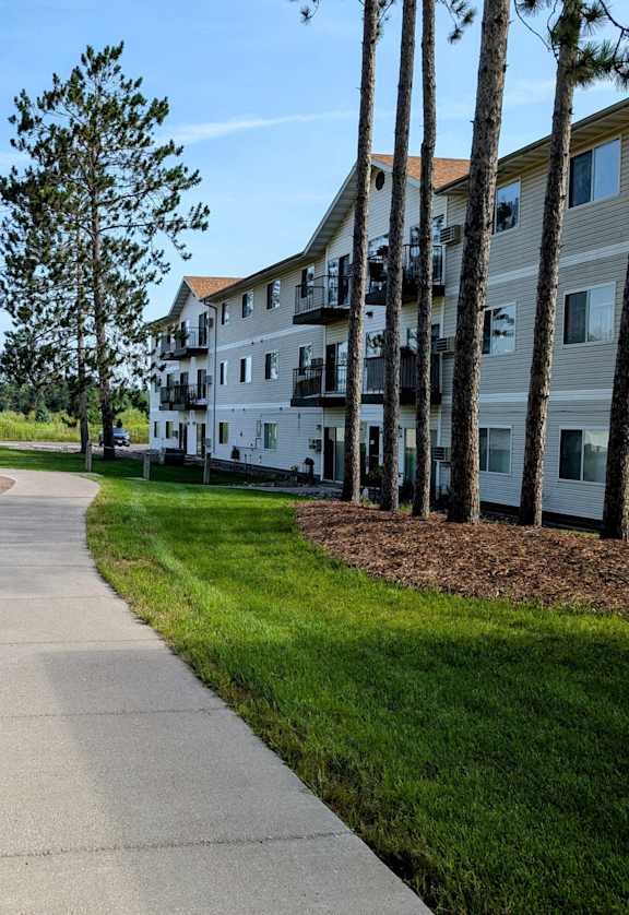 a sidewalk leading to a playground in front of a building