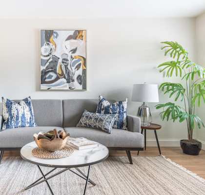 a living room with a gray couch and a white coffee table At Williamsburg Estates In Harrisburg, PA.