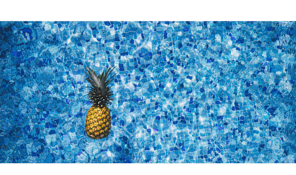 a pineapple floating in a swimming pool