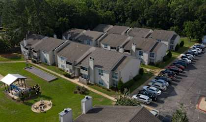 an aerial view of a row of houses with cars parked in front of them