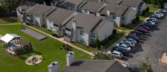 an aerial view of a row of houses with cars parked in front of them