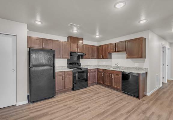 a kitchen with wooden cabinets and black appliances