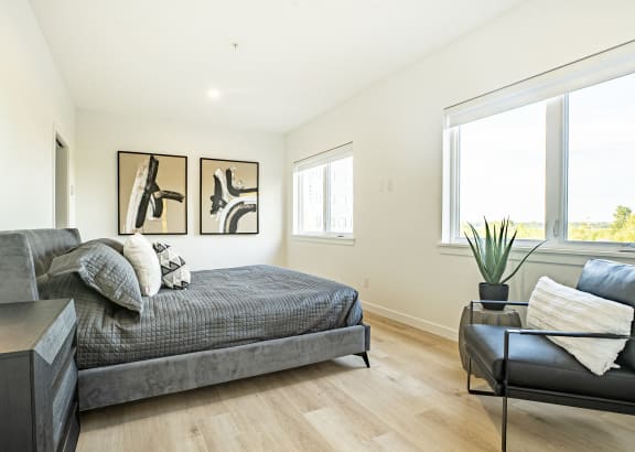 a bedroom with a couch and a bed and a large window