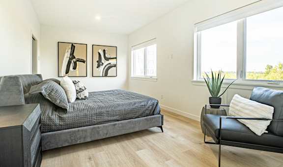 a bedroom with a couch and a bed and a large window