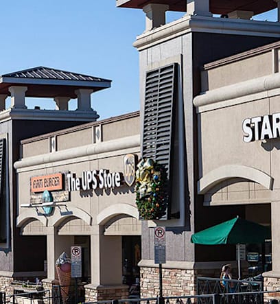A UPS store is located next to a Starbucks.